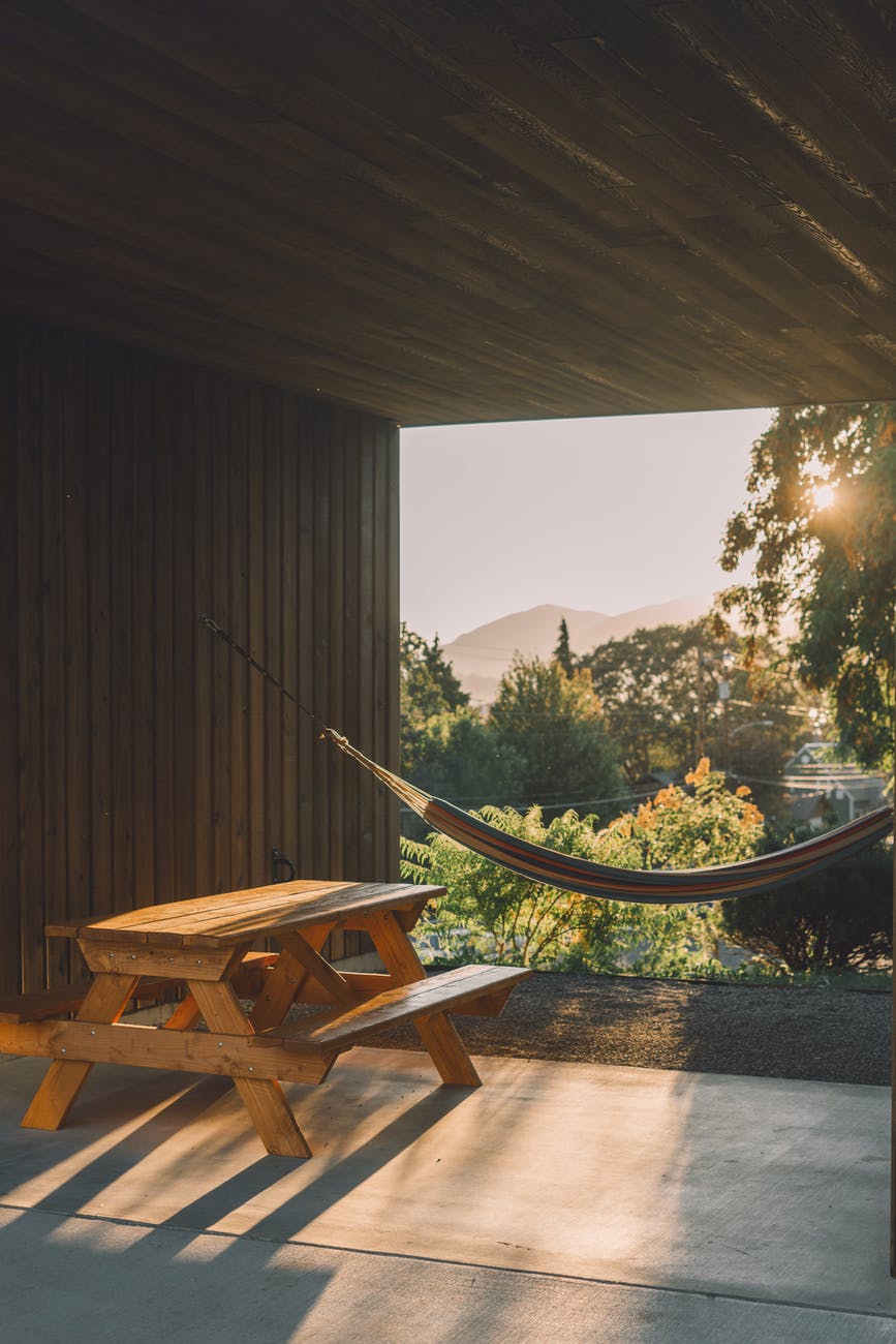 hammock near wooden table on terrace in sunshine