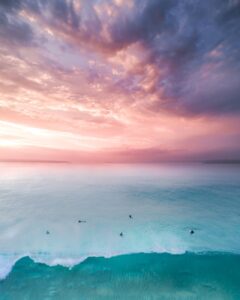 seascape of a turquoise water under a pink sunset sky